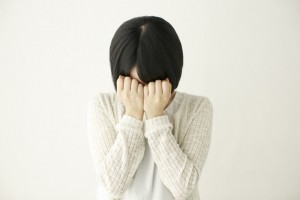 顔を隠して泣く日本人女性