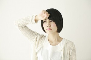 額に手を当てる日本人女性